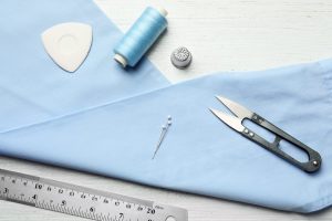 Flat lay composition with accessories for tailoring on wooden table Flat lay composition with accessories for tailoring on wooden table